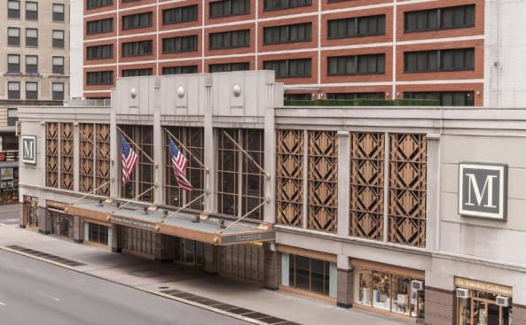 un edificio con dos banderas delante en The Manhattan at Times Square, an IHG Hotel, en Nueva York