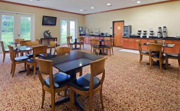 comedor con mesas y sillas y cocina en Best Western Inn & Suites Cleveland, en Cleveland