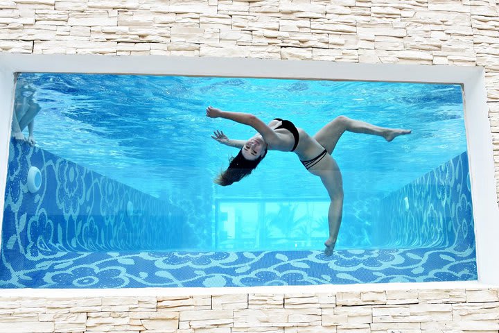 Piscina con pared de cristal