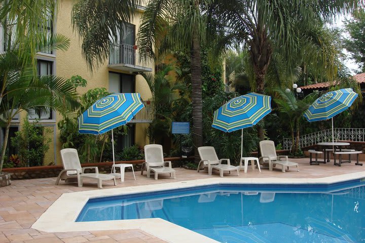 Sun loungers with a shade next to the pool at Quinta del Gobernador hotel