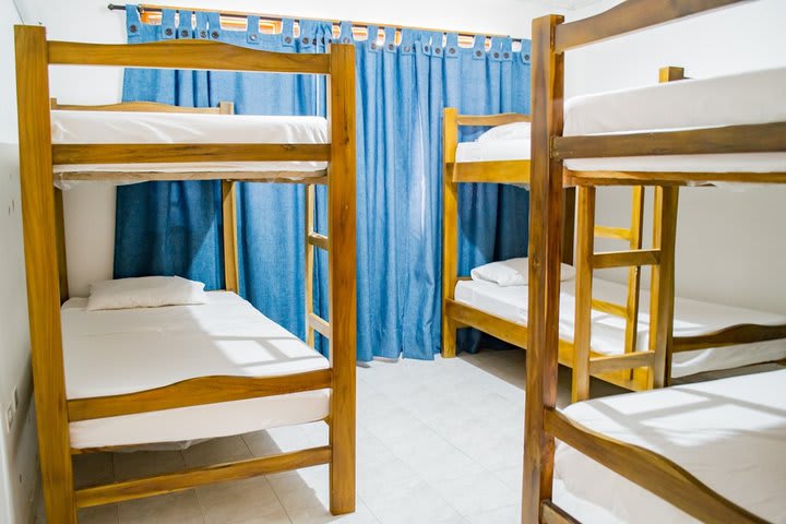 Cama en dormitorio compartido mixto con baño exterior