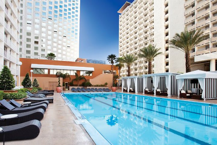 Solárium con piscina y camas de playa plegables