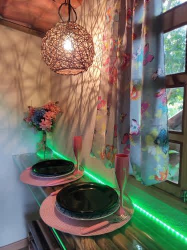 a table with two plates and glasses of wine and a chandelier at Hostel Portal Das Fadas, in Cavalcante