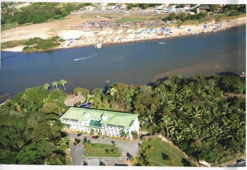 un edificio con techo verde junto a una playa en el HOTEL ARAGUAIA, en Barra do Garças