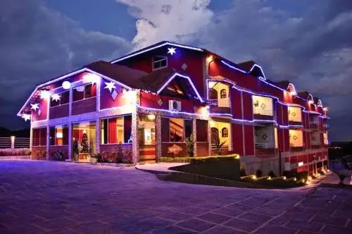 una casa iluminada por la noche con luces en el Hotel do Papai Noel, en Penedo