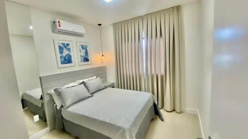 Habitación blanca con cama y ventana en el HY Apart Hotel, en Bombinhas