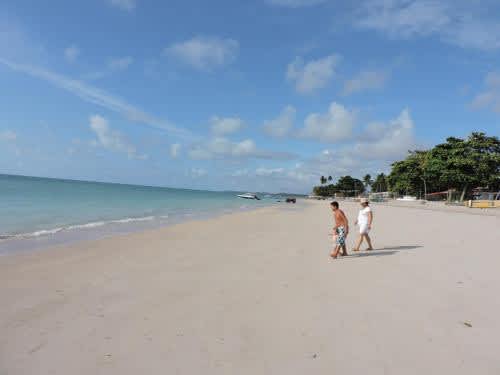 Un par de personas paseando por la playa de Cantinho da Melão, en Maragogi