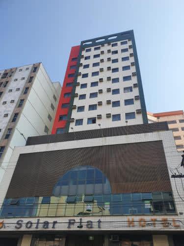 un edificio alto y blanco con un letrero en el Hotel Solar Flat, en Juiz de Fora