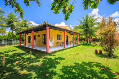 una pequeña casa amarilla con patio en Chales Maragogi, en Maragogi