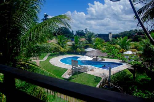 vistas a la piscina y las palmeras de la Pousada Recanto Caiçara, en São Miguel dos Milagres