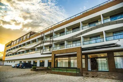 un edificio grande con un estacionamiento frente a él en el Hotel Titanic Penedo, en Penedo
