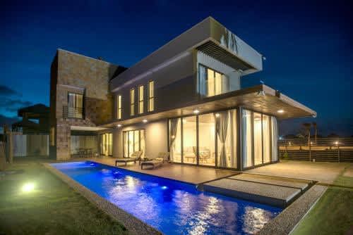 una casa con piscina por la noche en Illa Blue Village, en Trairi