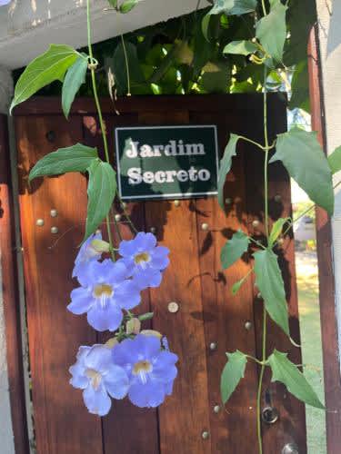 a sign that says garden sector next to blue flowers in Jardim Secreto - Itaipava, in Itaipava