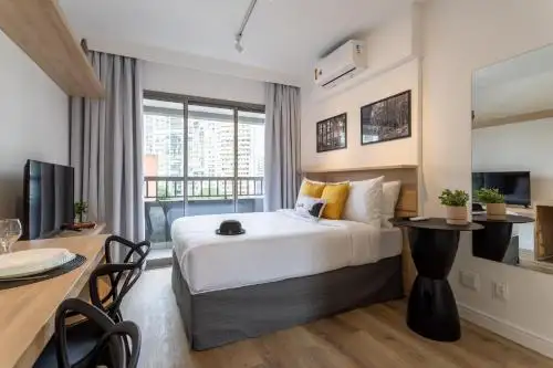 Habitación de hotel con cama y mesa de comedor en el Smart Charlie Parque Augusta Mackenzie, en São Paulo