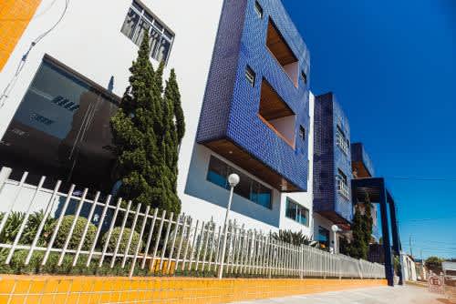un edificio azul con una cerca frente al Cafezal Palace Hotel, en Vitória da Conquista