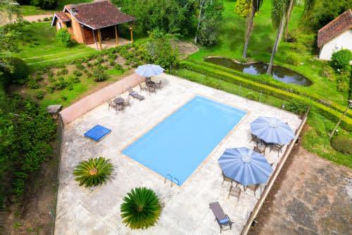 vista aérea de una piscina con sombrillas en el VELINN Hotel Fazenda Fonte das Horténsias, en Santo Antônio do Pinhal