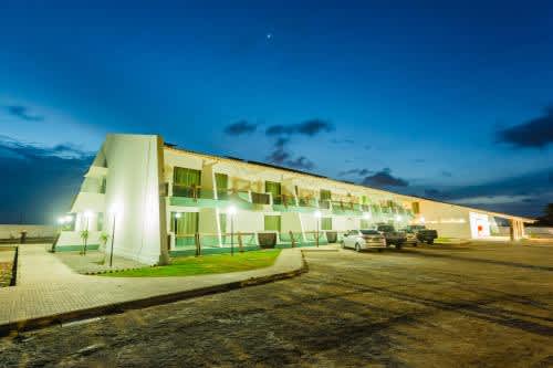 un edificio con autos estacionados en un estacionamiento en Arrey Hotel Beach, en Parnaíba