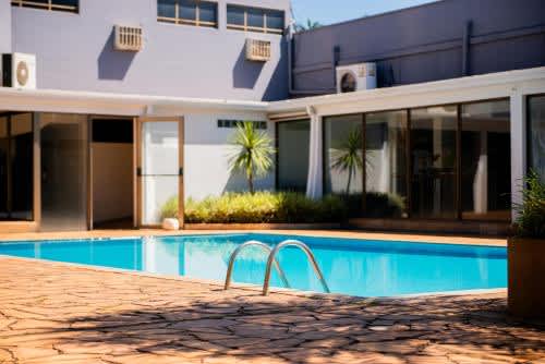 una piscina frente a una casa en el Hotel Fernandão, en Pouso Alegre