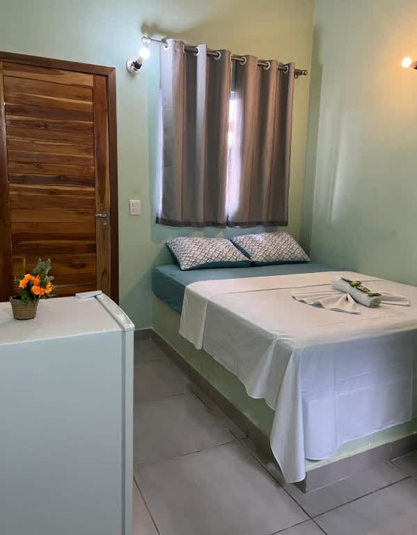 1 dormitorio con 1 cama con lavabo y ventana en la Pousada Certa Express, en Chapada dos Guimarães
