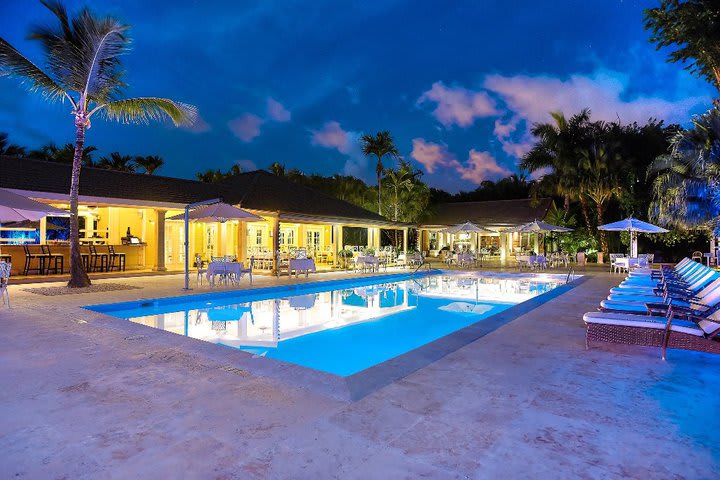 Vista nocturna del área de la piscina