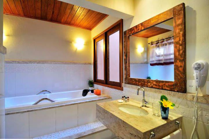 Guest room with tub at Jambo Pousada in Itacimirim