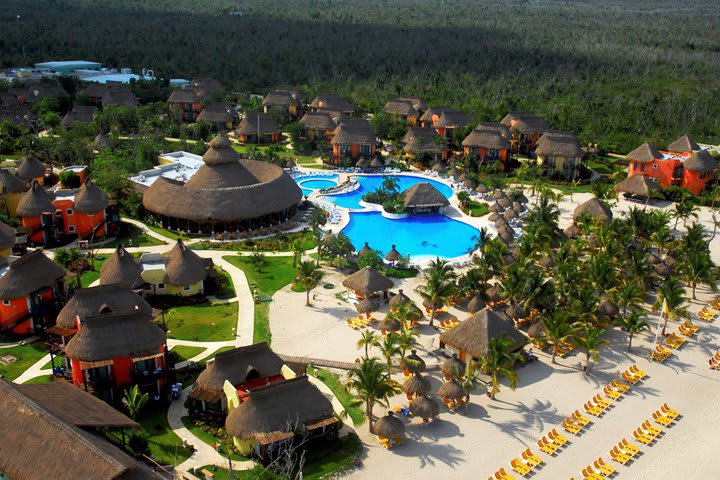 Aerial view of the beach, pools, and rooms