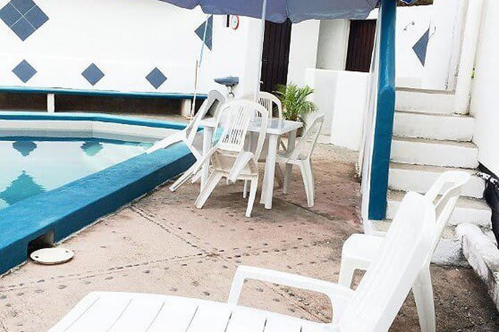 Table and sun loungers next to the pool