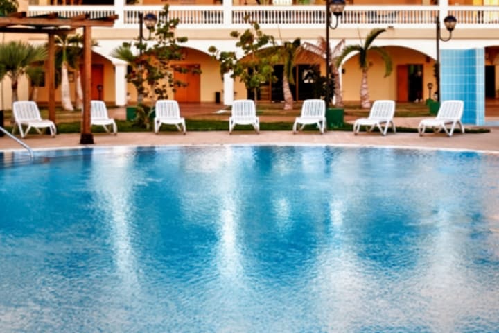 Vista de la piscina con camas de playa plegables