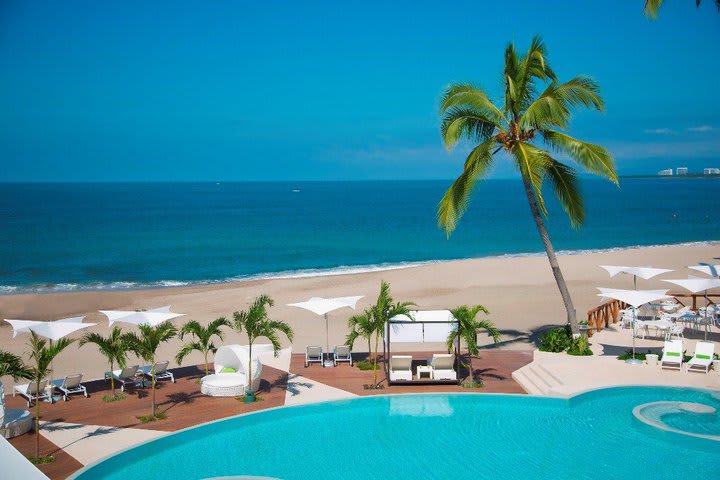 La piscita está rodeada de camas de playa plegables y camas balinesas