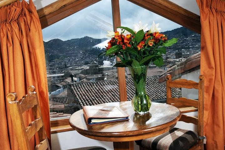 Mesas y sillas en una habitación de Casa San Blas, hotel en Cuzco