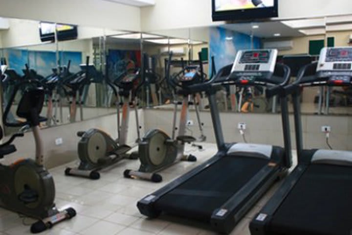 Workout in the fitness center at Golden Beach Flats, hotel in Recife