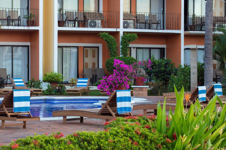 The pool has a sitting area with sun loungers