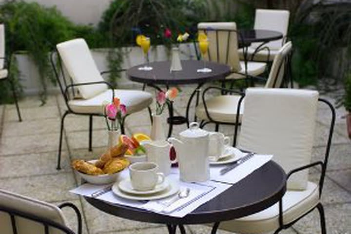 Terraza con mesa y sillas en el hotel Ramada Tour Eiffel en Parìs