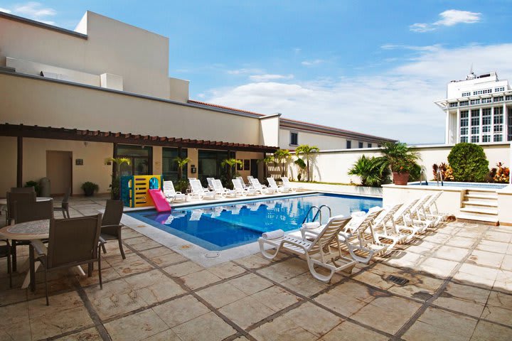 Outdoor pool surrounded by sun loungers