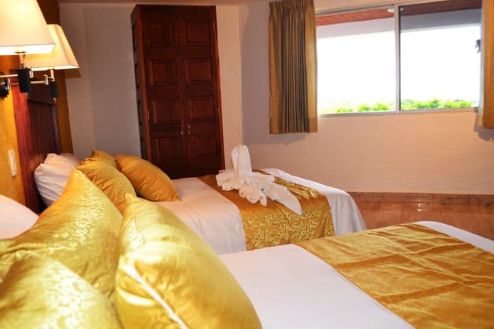 Guest room with two beds at the Rinconada de Cortes hotel in Cuernavaca