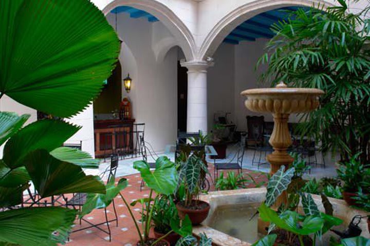 Patio del hotel con una fuente y plantas