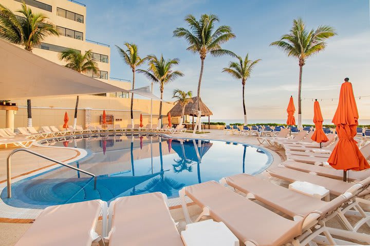 Piscina rodeada de camas de playa