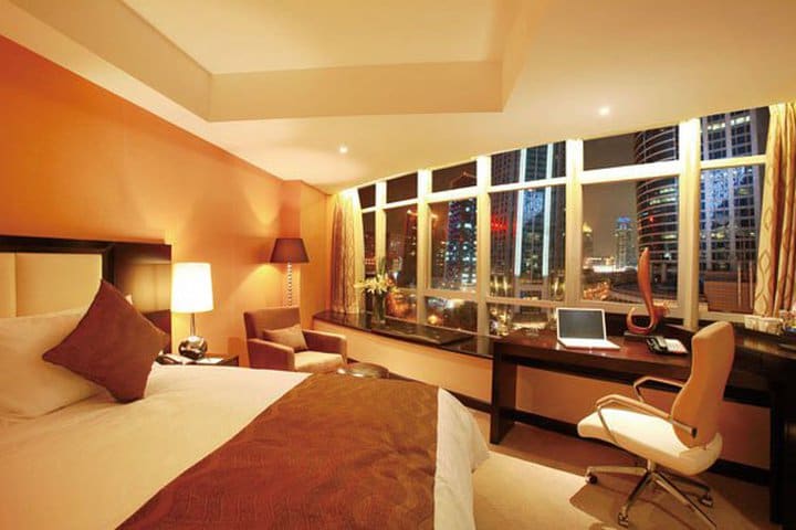 Guest room with work desk and city view at the Howard Johnson Business Club Hotel Shanghai