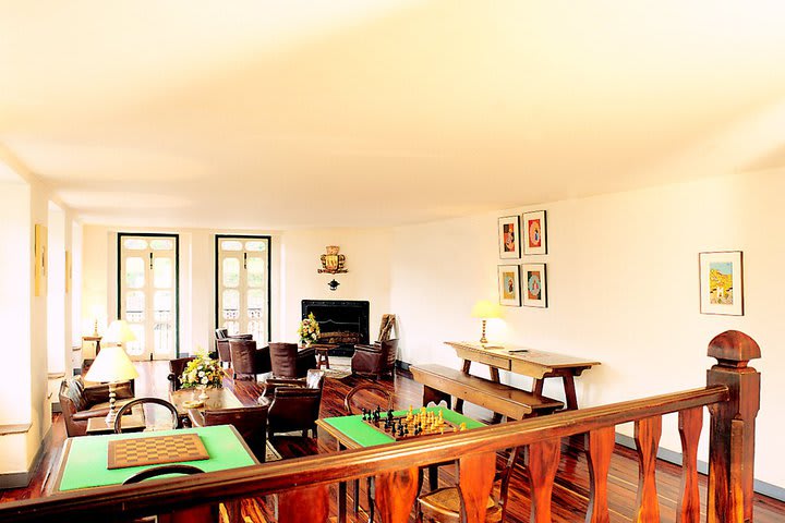 Salón con juegos de mesa y chimenea en el hotel Luxor Ouro Preto Pousada