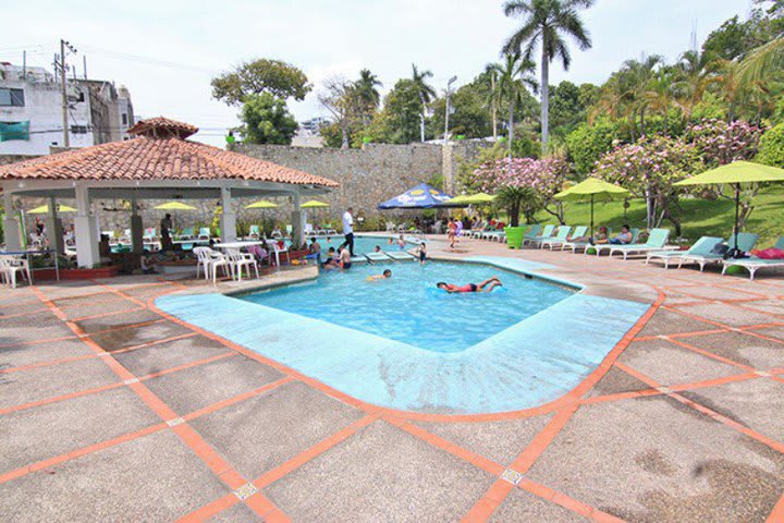 Piscina exterior rodeada de camas de playa