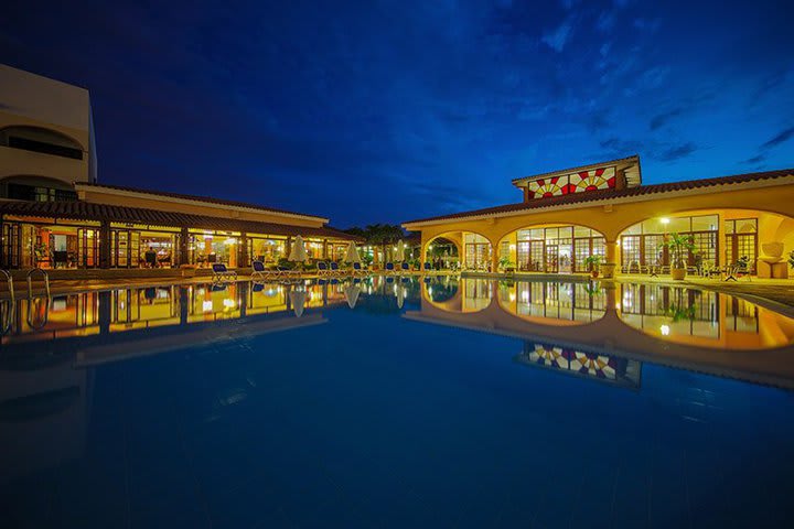 Vista nocturna del área de piscina