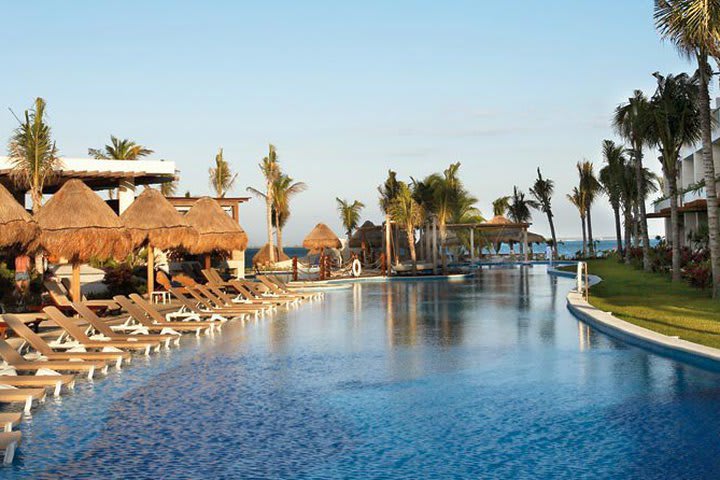 Camas de playa plegables alrededor de una piscina