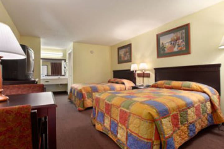 Guest room with two double beds at the Howard Johnson Enchanted Land hotel in Kissimmee