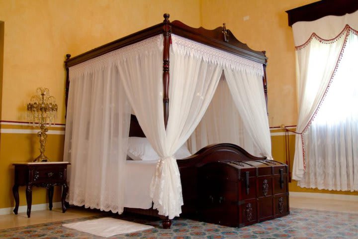 Cama dentro de una habitación del hotel Hacienda Kaan Ac