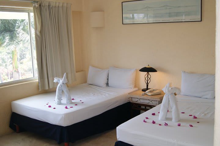 Guest room with two double beds at the Villamar Princesa Suites hotel in Acapulco